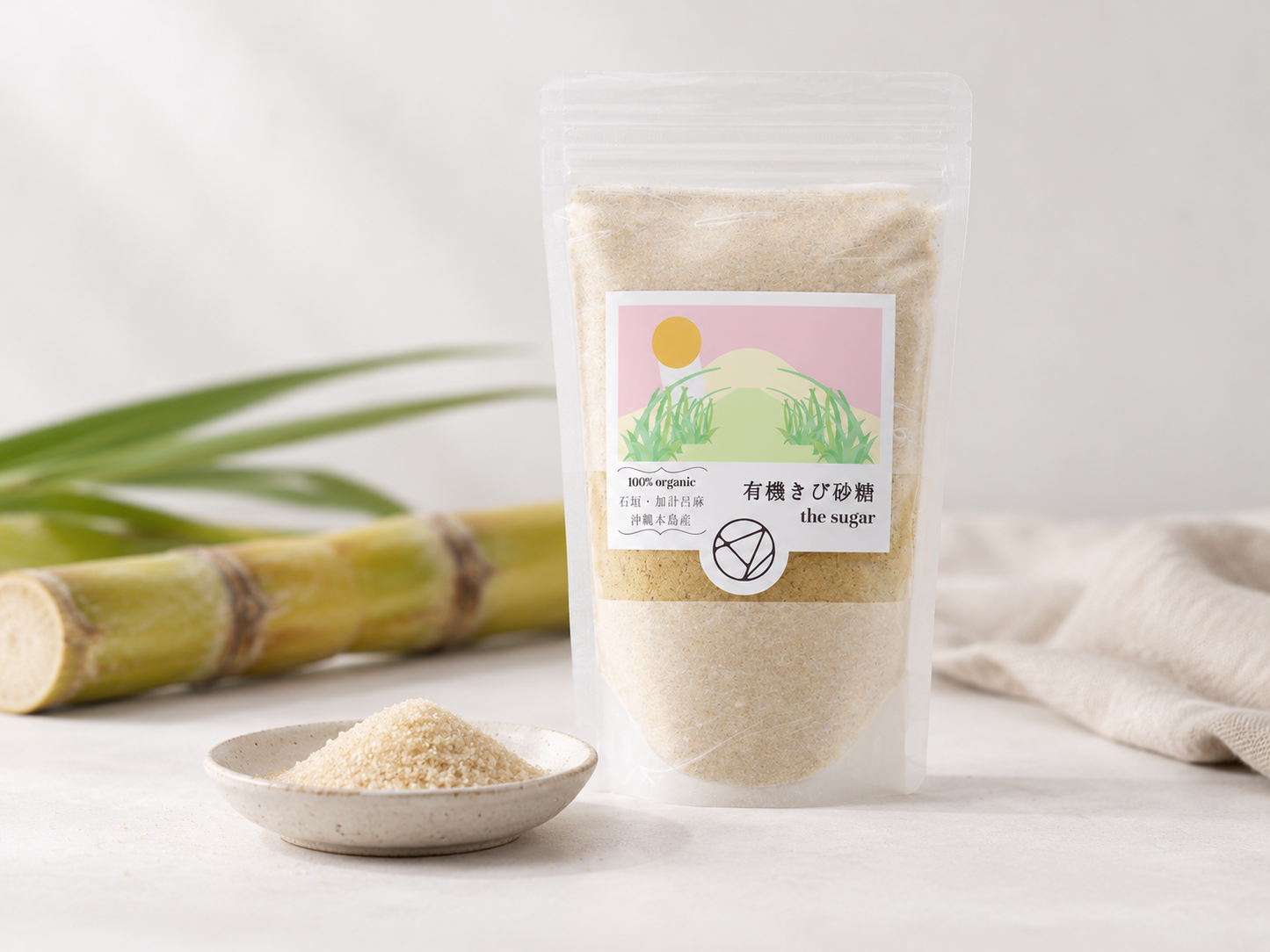 ALE ONEの有機きび砂糖「the sugar」と、サトウキビ、小皿に盛ったきび砂糖を写した画像